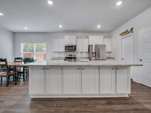 kitchen featuring white cabinets, a kitchen island with sink, sink, and appliances with stainless steel finishes