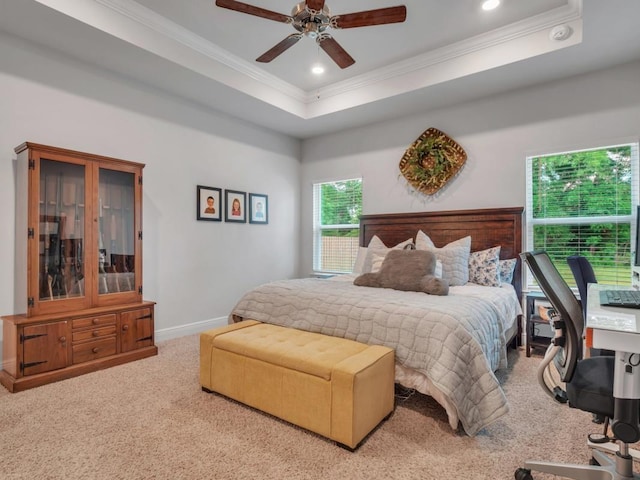 carpeted bedroom with ceiling fan, a raised ceiling, and crown molding