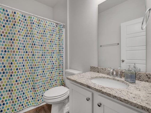 bathroom featuring hardwood / wood-style floors, vanity, toilet, and walk in shower