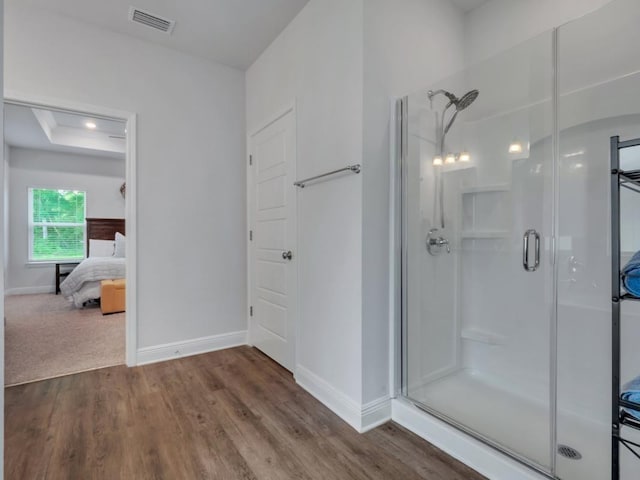 bathroom with hardwood / wood-style flooring and walk in shower