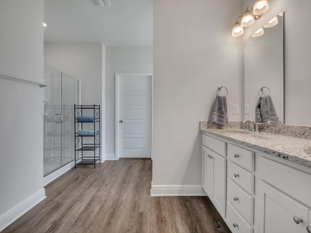 bathroom with wood-type flooring, vanity, and a shower with shower door