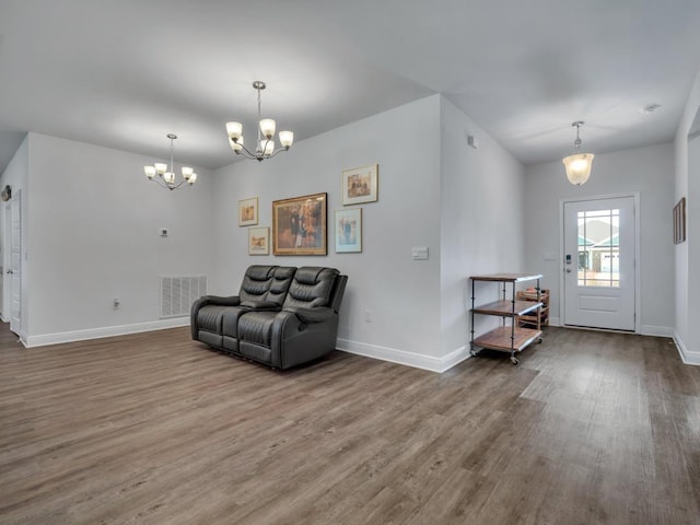 living area featuring wood-type flooring and a notable chandelier