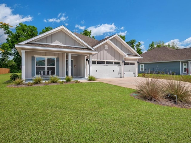 view of front of house with covered porch, a garage, and a front yard