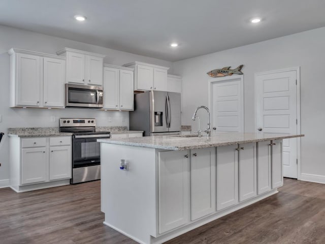 kitchen featuring white cabinetry, stainless steel appliances, and a kitchen island with sink