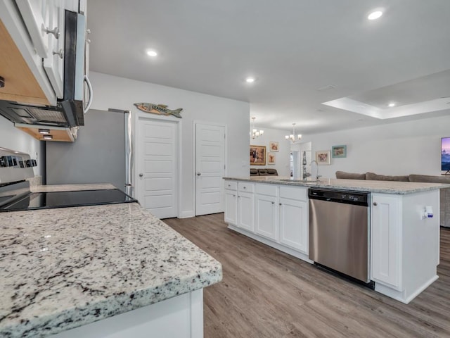 kitchen with stove, dishwasher, white cabinetry, hanging light fixtures, and an island with sink