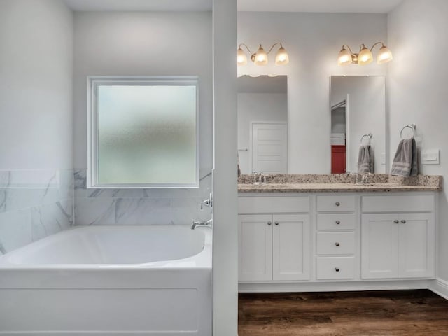 bathroom featuring a washtub, vanity, and hardwood / wood-style flooring