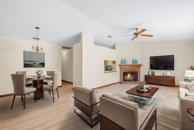 living room with ceiling fan, light hardwood / wood-style floors, and a brick fireplace