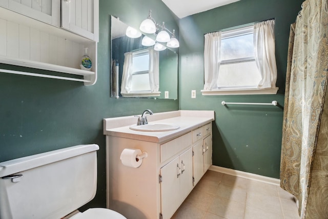 bathroom with toilet, tile patterned flooring, baseboards, and vanity