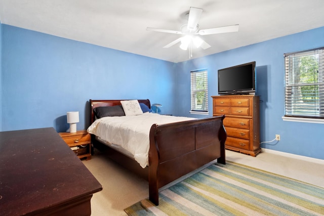 bedroom featuring light carpet, ceiling fan, and baseboards