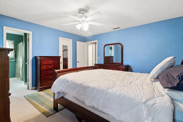 bedroom with a ceiling fan, visible vents, carpet flooring, and ensuite bathroom