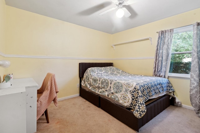 carpeted bedroom with ceiling fan and baseboards