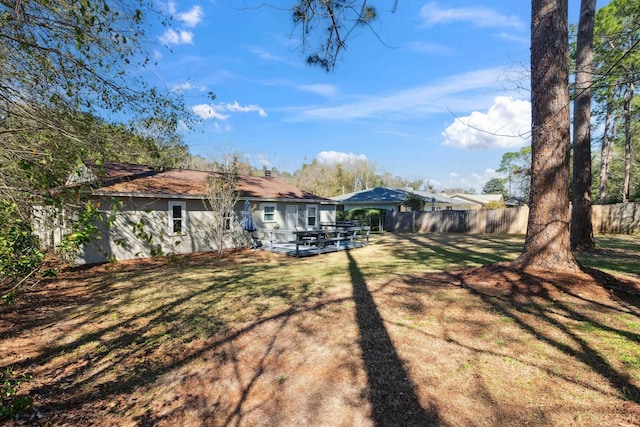 back of house with a yard, fence, and a deck