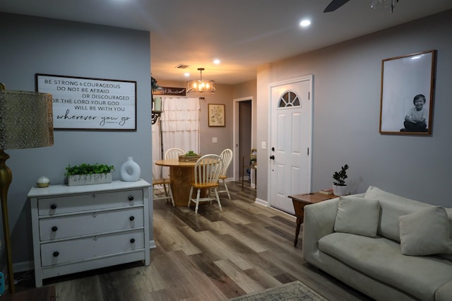 living room featuring recessed lighting, wood finished floors, ceiling fan with notable chandelier, baseboards, and visible vents