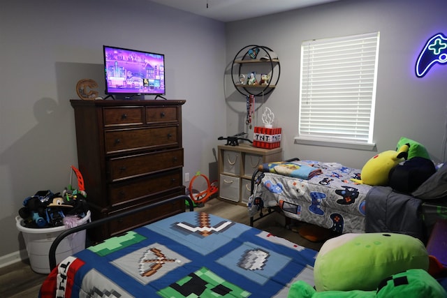 bedroom featuring wood finished floors and baseboards