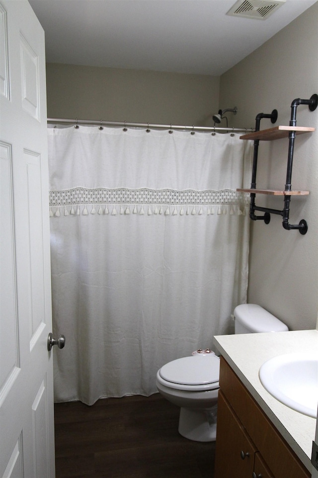 bathroom with hardwood / wood-style flooring, vanity, and toilet