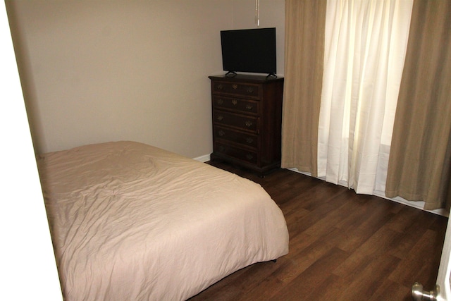 bedroom with dark hardwood / wood-style floors