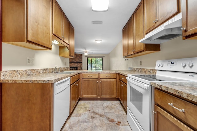2398 Continental Ave, Tallahassee, FL 32304 - kitchen featuring white appliances, under cabinet range hood, brown cabinetry, stone finish floors, and a fireplace
