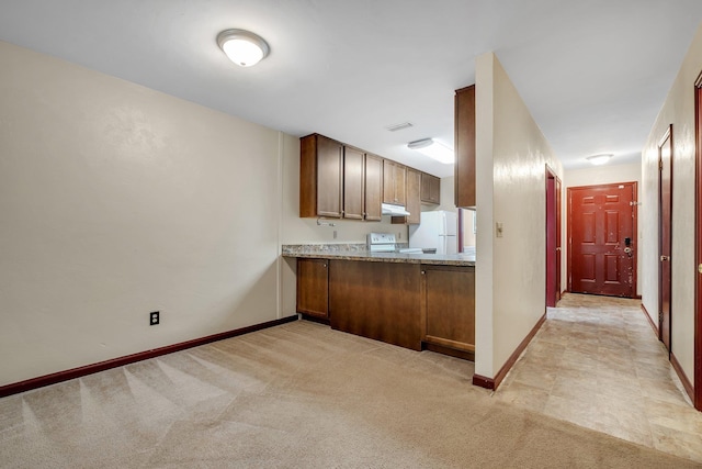 2398 Continental Ave, Tallahassee, FL 32304 - kitchen with white appliances, under cabinet range hood, light colored carpet, and light countertops