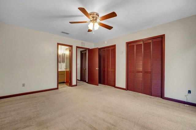 2398 Continental Ave, Tallahassee, FL 32304 - unfurnished bedroom featuring multiple closets, light carpet, connected bathroom, and a ceiling fan