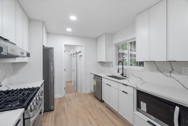 1102 Betton Rd, Tallahassee, FL 32308 - kitchen with a sink, stainless steel appliances, white cabinets, under cabinet range hood, and light wood-style flooring