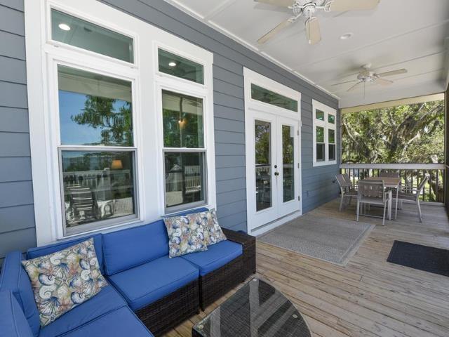 wooden terrace featuring french doors, outdoor dining space, outdoor lounge area, and a ceiling fan