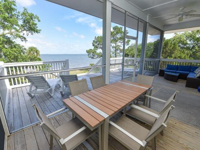 wooden deck featuring outdoor lounge area, outdoor dining area, a water view, and a ceiling fan