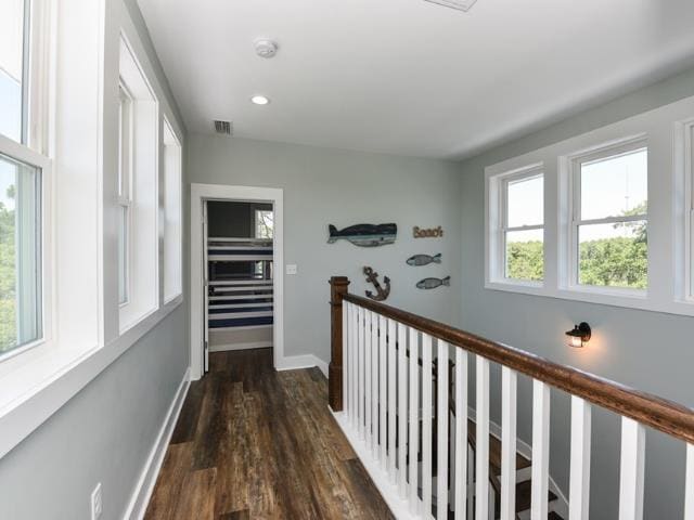 hall featuring dark wood-style floors, recessed lighting, visible vents, an upstairs landing, and baseboards