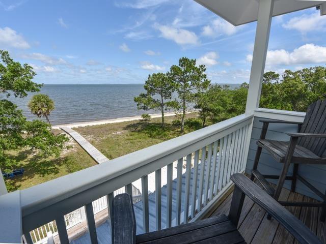 balcony with a water view and a view of the beach