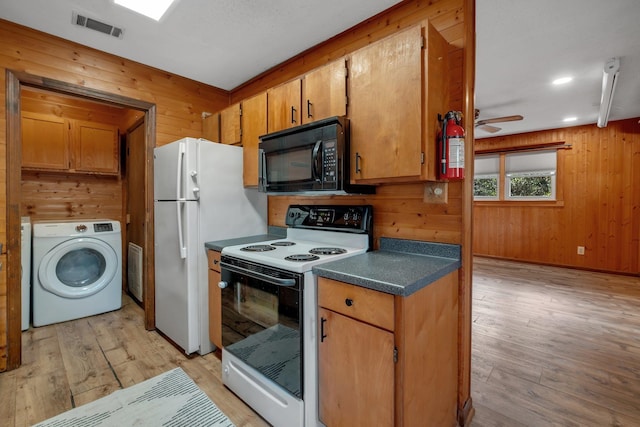 kitchen with washer / clothes dryer, light hardwood / wood-style flooring, white appliances, and wood walls