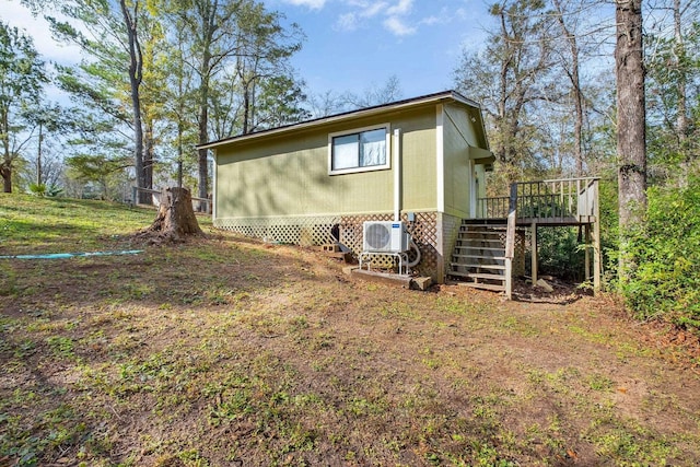 view of side of home with ac unit and a deck