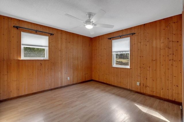 spare room with ceiling fan, light hardwood / wood-style flooring, and a textured ceiling