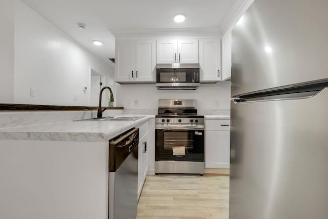 3204 N Ridge Rd, Tallahassee, FL 32305 - kitchen featuring appliances with stainless steel finishes, light wood-style floors, white cabinetry, a peninsula, and recessed lighting