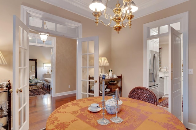 dining room with a notable chandelier, ornamental molding, and french doors