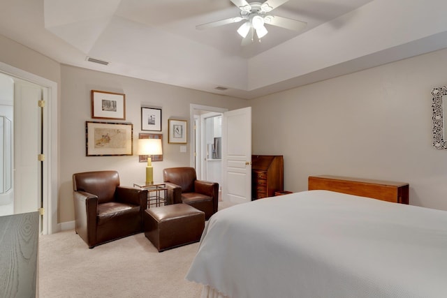 bedroom with light carpet, a raised ceiling, and ceiling fan