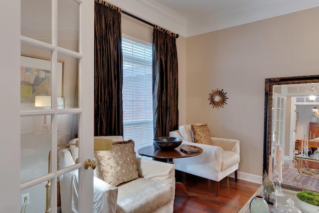 sitting room featuring wood-type flooring, ornamental molding, and french doors