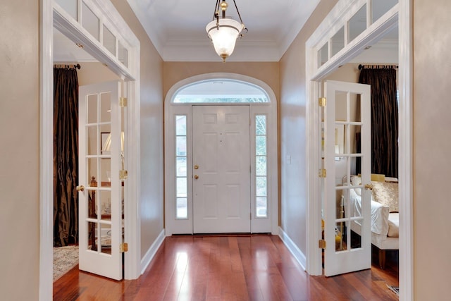 foyer entrance with hardwood / wood-style flooring and ornamental molding