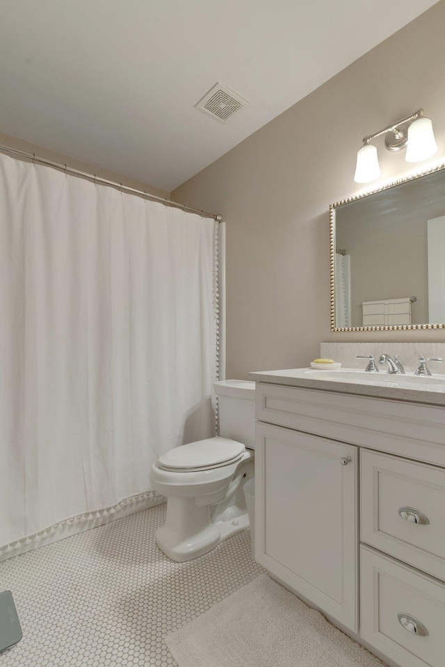 bathroom featuring tile patterned flooring, vanity, and toilet