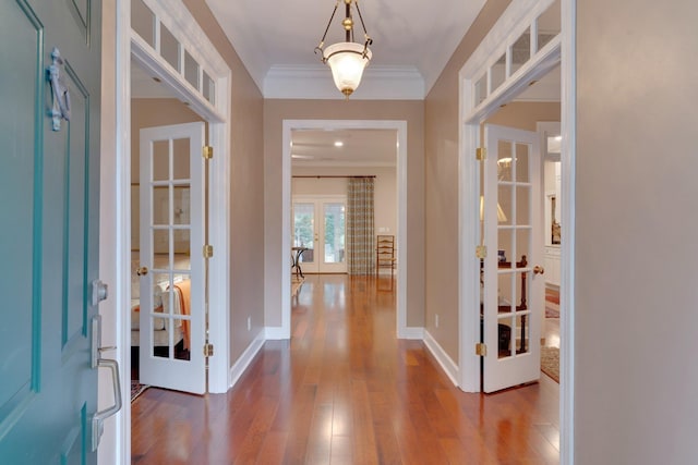 foyer with french doors, crown molding, and hardwood / wood-style floors