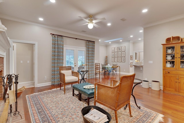 sitting room with french doors, ceiling fan, ornamental molding, and light hardwood / wood-style floors