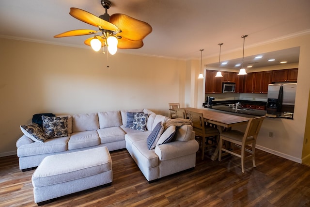 living room featuring crown molding, dark wood-type flooring, sink, and ceiling fan