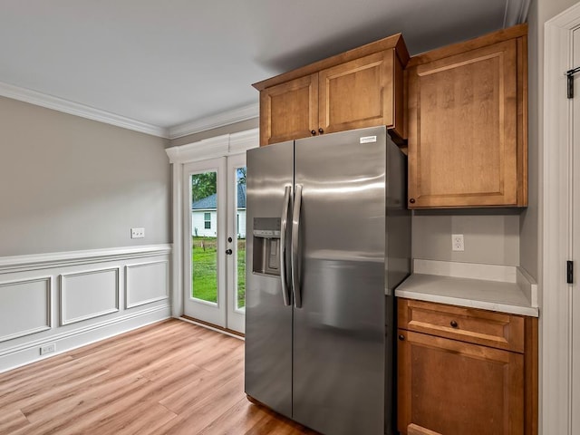 kitchen featuring stainless steel fridge with ice dispenser, ornamental molding, and light hardwood / wood-style flooring