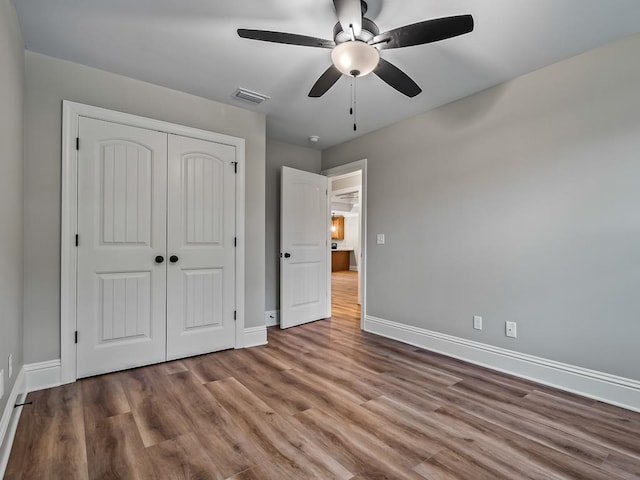 unfurnished bedroom with ceiling fan, light hardwood / wood-style floors, and a closet