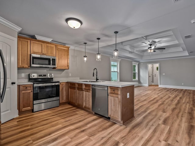 kitchen with stainless steel appliances, sink, hanging light fixtures, kitchen peninsula, and ceiling fan