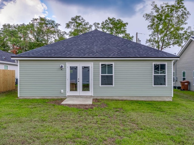 rear view of house with french doors and a lawn