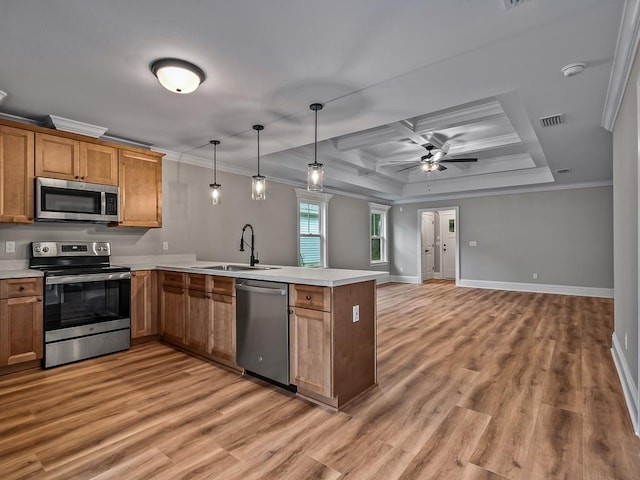 kitchen featuring stainless steel appliances, crown molding, kitchen peninsula, and hanging light fixtures