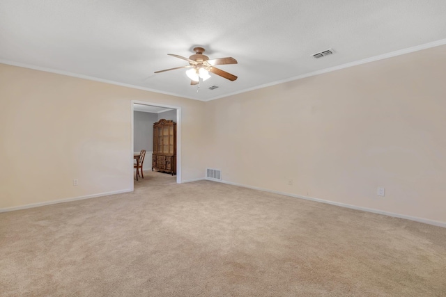 carpeted empty room with ceiling fan and crown molding