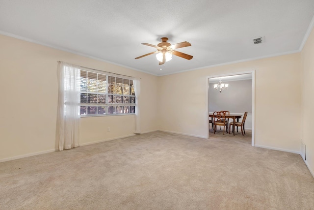 carpeted empty room featuring ceiling fan with notable chandelier and ornamental molding