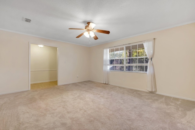 carpeted spare room with ceiling fan and ornamental molding