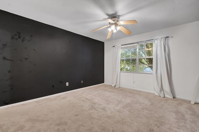 carpeted empty room with ceiling fan and a textured ceiling