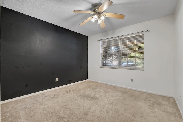 carpeted spare room with ceiling fan and a textured ceiling